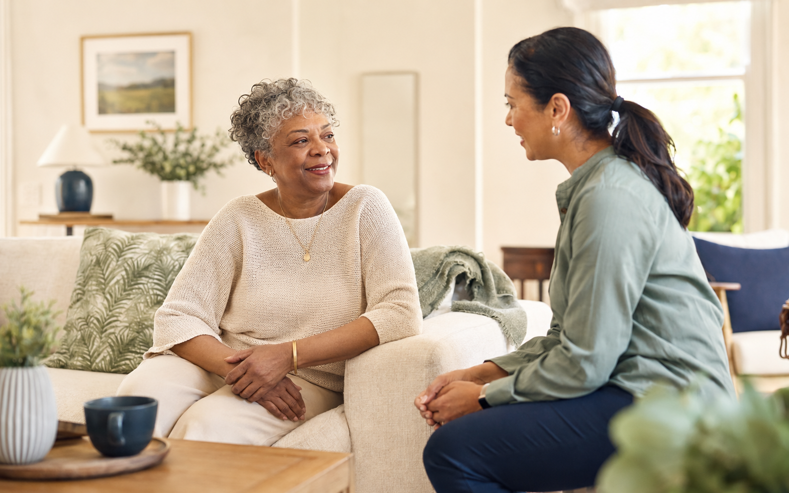 A caregiver having a warm conversation with an older adult at home